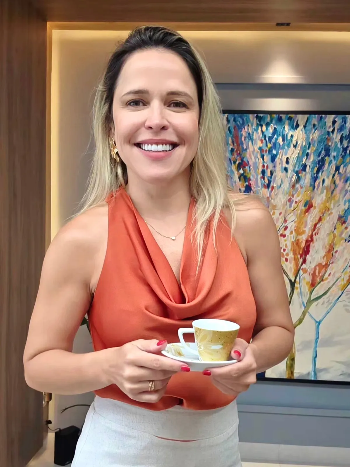 Dra. Silvia no consultório com uma xícara de café